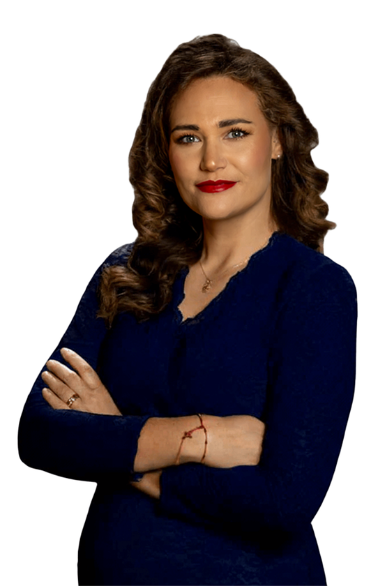 Woman in a navy dress with arms crossed, standing against a white background.