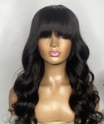 A mannequin is wearing a black wig with bangs.