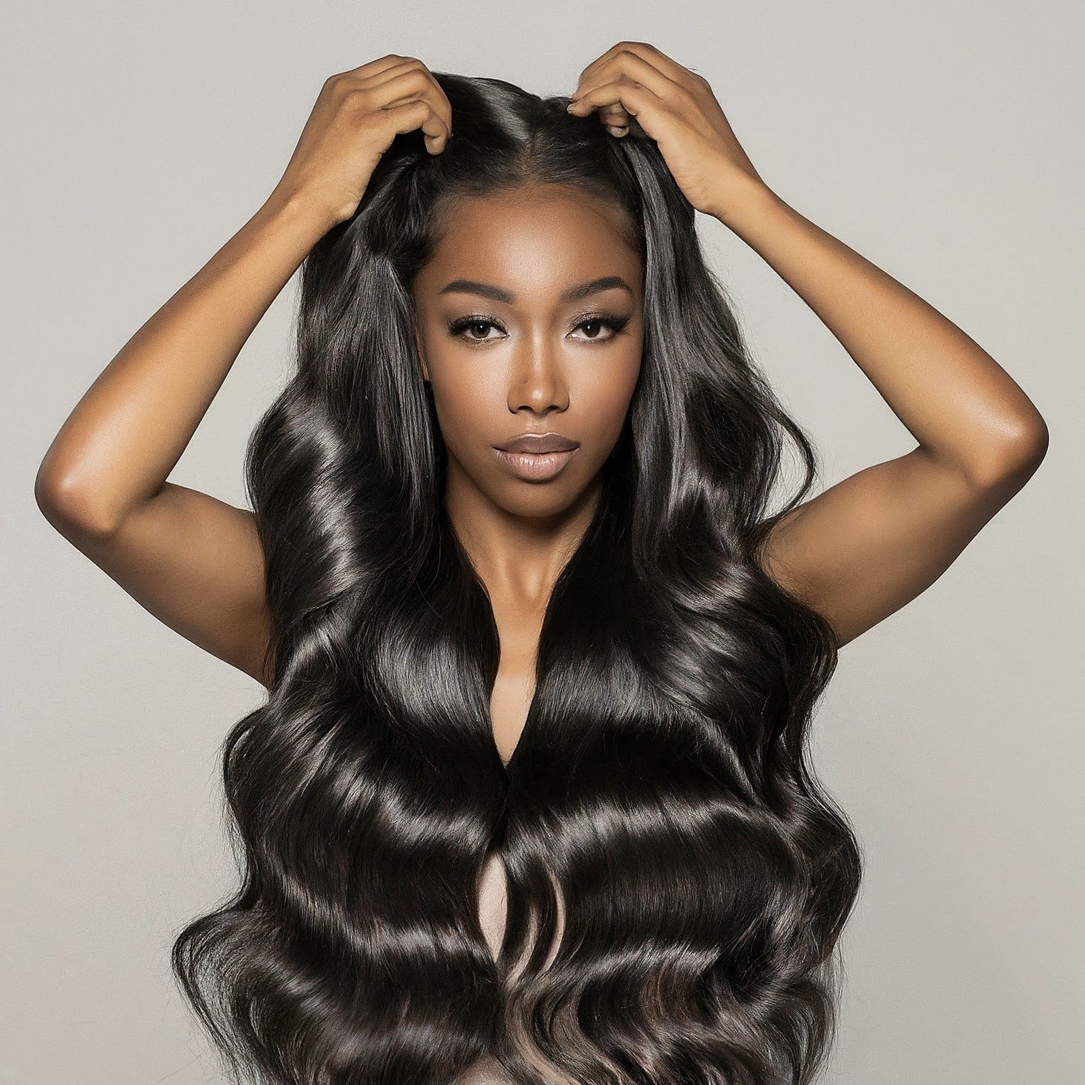 A woman with very long hair is holding her hair in her hands
