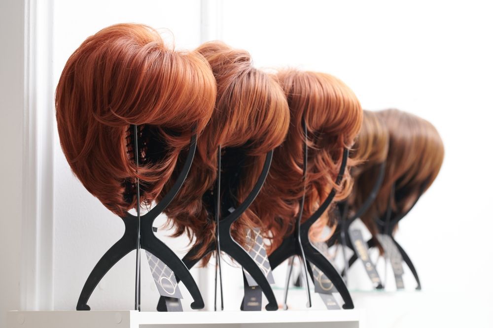 A row of wigs sitting on top of a shelf.