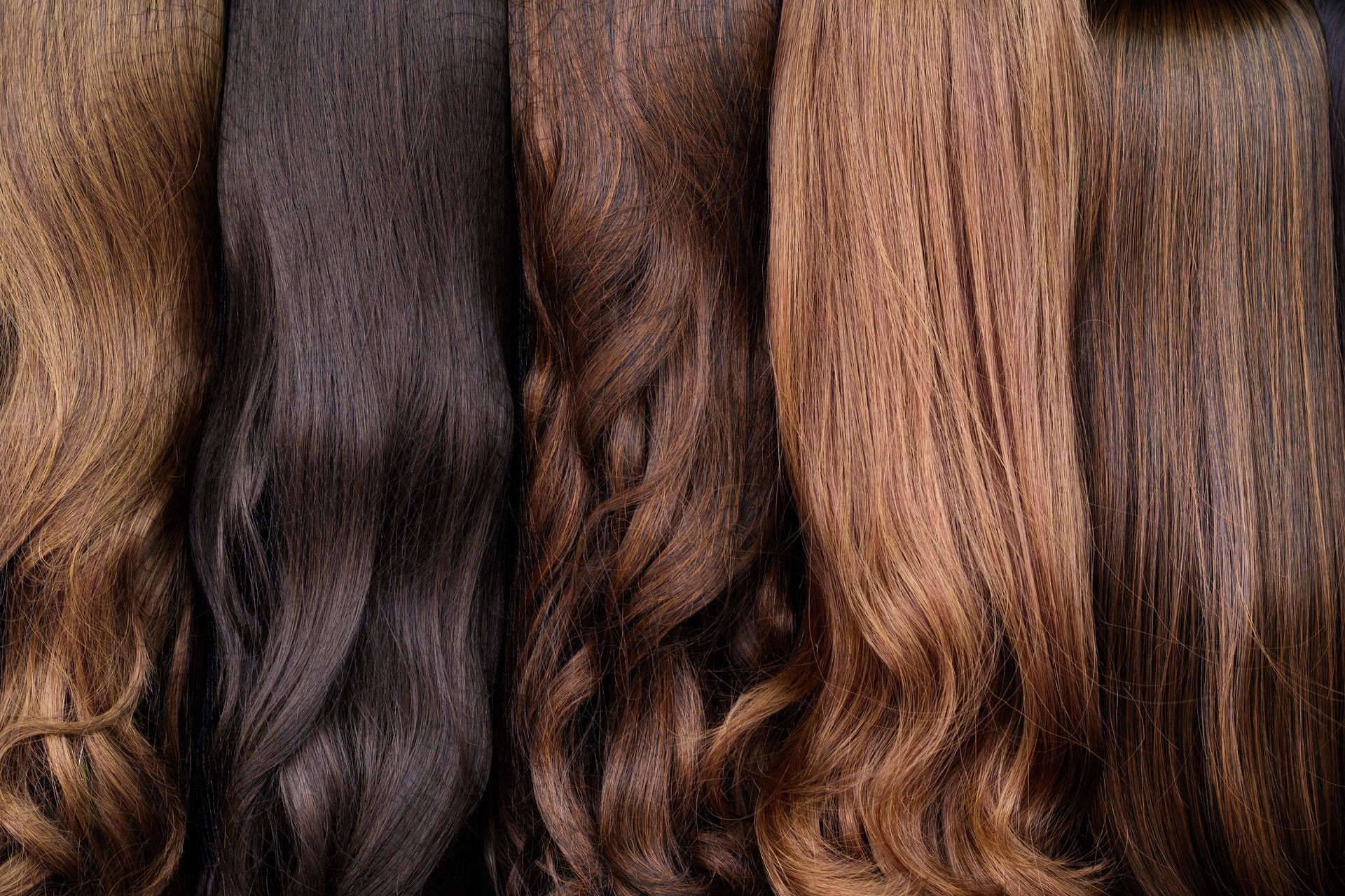 A close up of a bunch of different colored hair extensions.