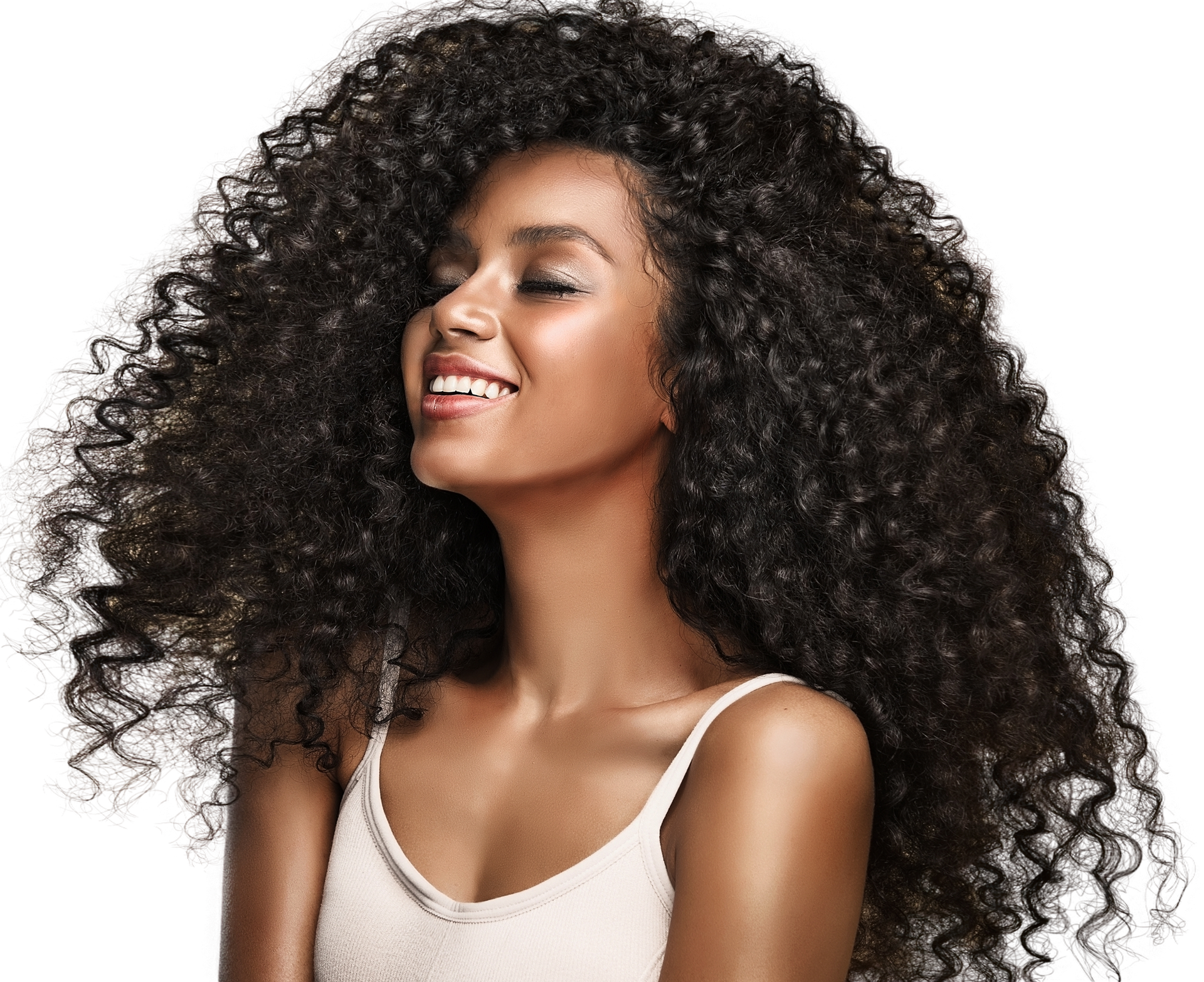 A woman with very long curly hair is smiling.