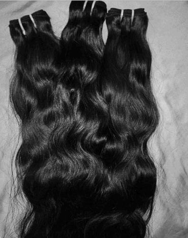 A bunch of black hair is stacked on top of each other on a table.