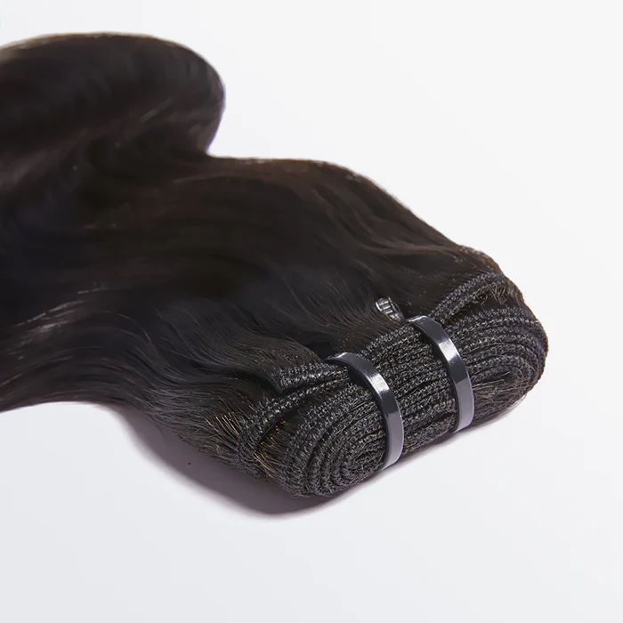 A close up of a bundle of hair on a white surface