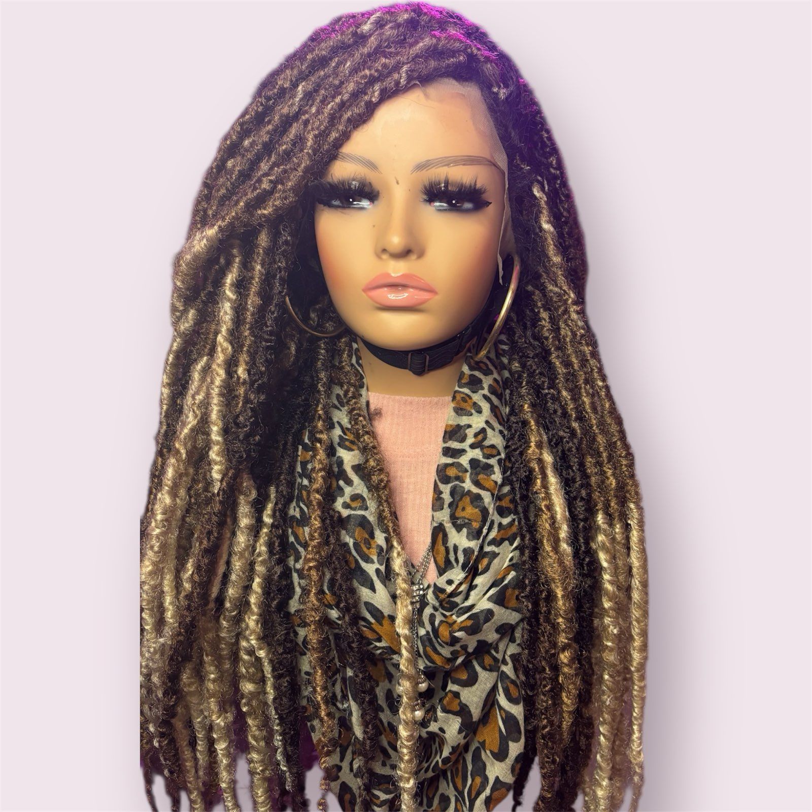 Mannequin with long brown and blonde dreadlocks styled in a top bun