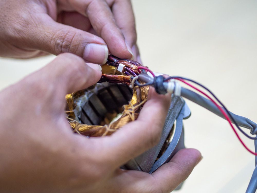 A Person Is Holding A Piece Of Electronic Equipment In Their Hands — Edmonton Car Air in Port Douglas, QLD