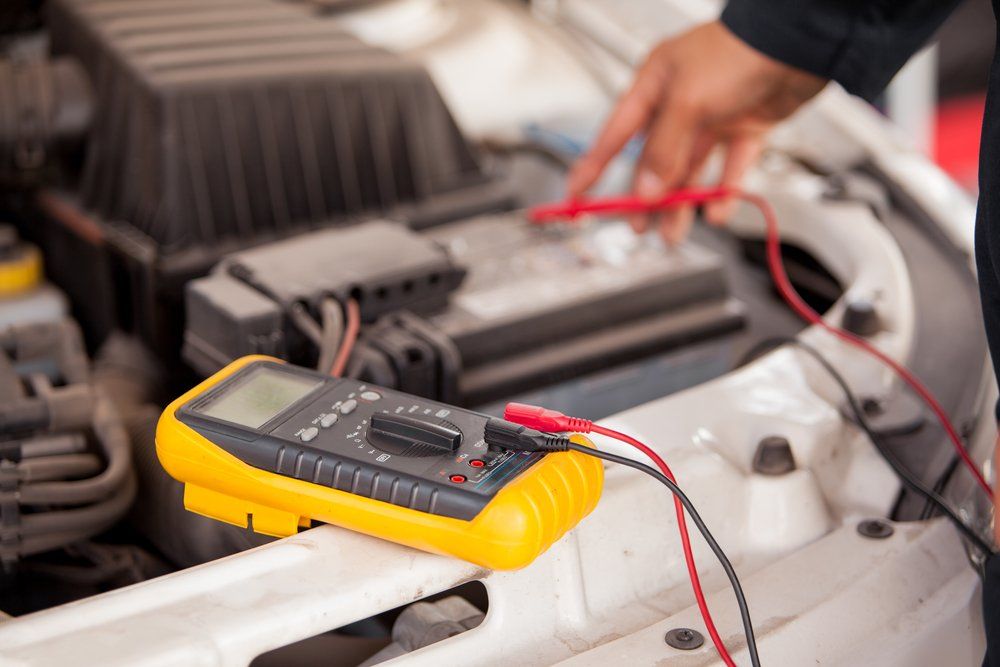 Closeup of the Hands of a Mechanic Checking a Car Battery — Edmonton Car Air in Bentley Park, QLD