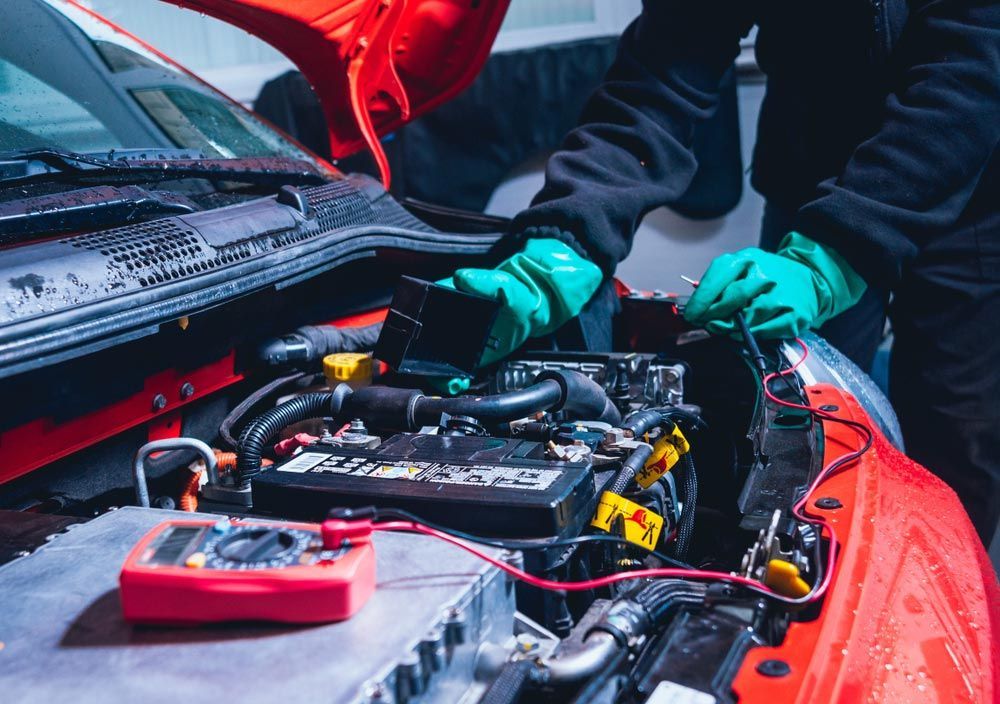 A Man Is Working On The Engine Of A Red Car — Edmonton Car Air in Bentley Park, QLD