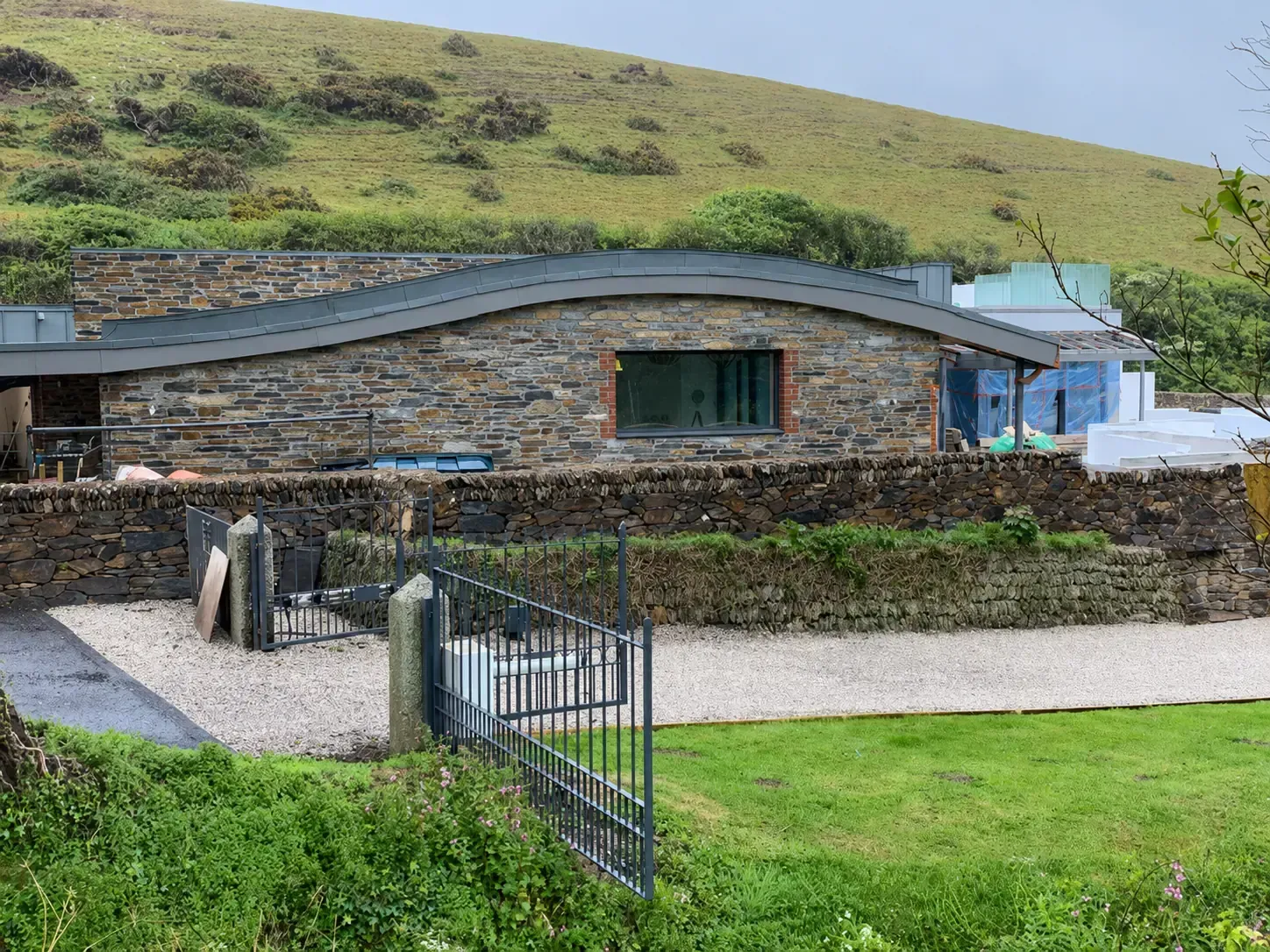 Completed curved metal roof on a stone building