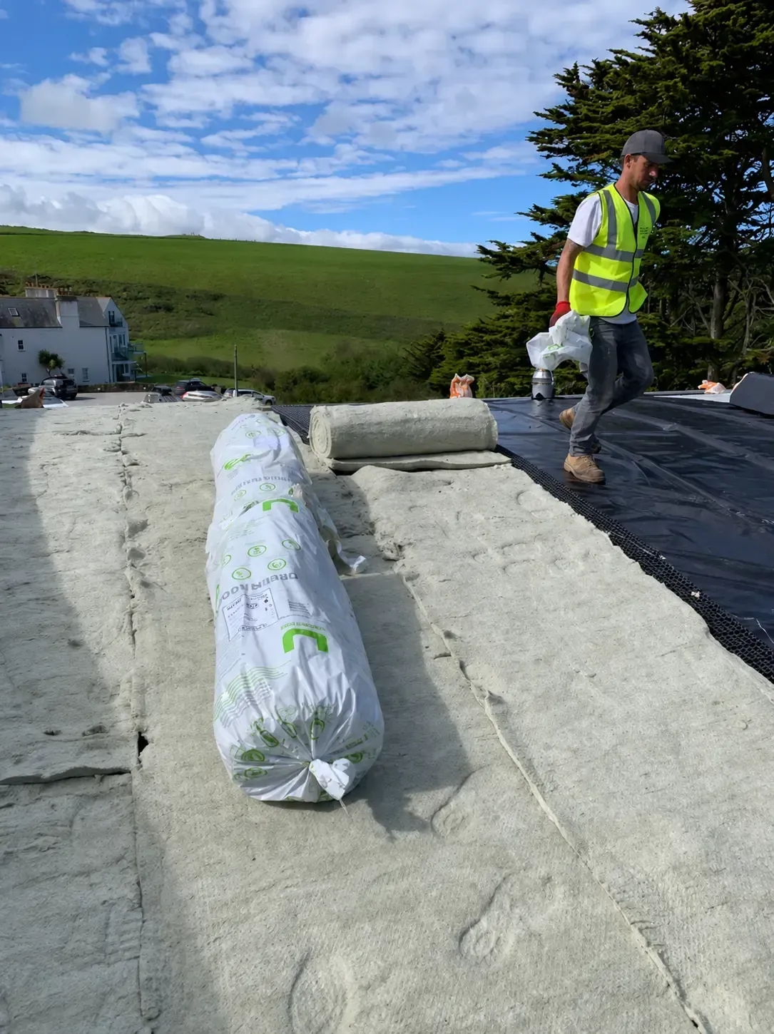 Roofing contractor installing insulation and membrane on a flat roof