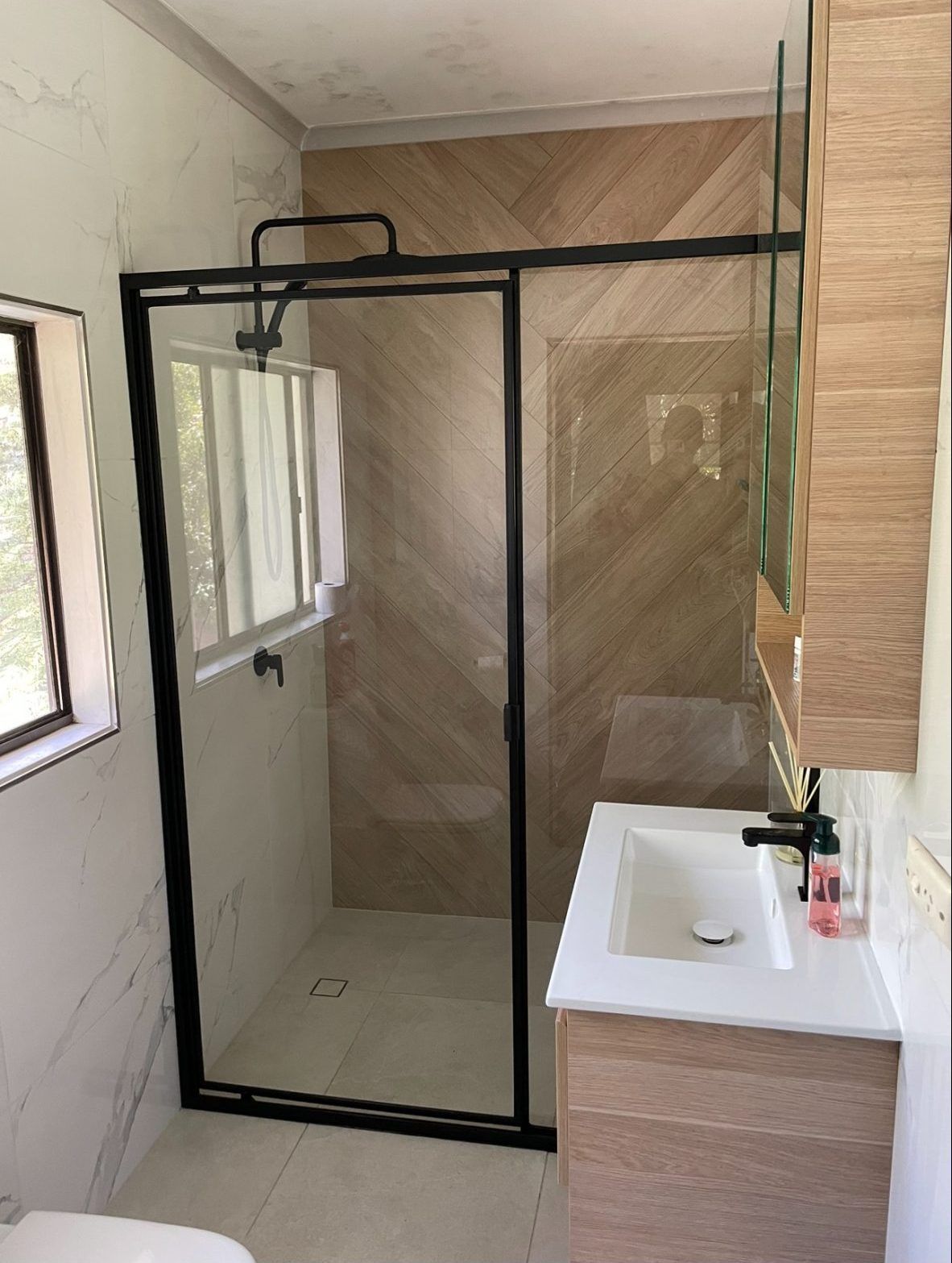A Bathroom With a Walk in Shower , Sink , Toilet and Window — Ideal Glass In Winnellie, NT