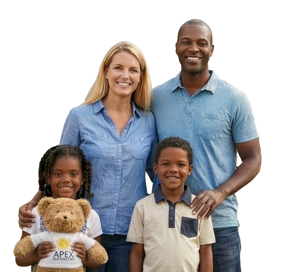 Family of four smiling, posing for a photo. A child holds a teddy bear.