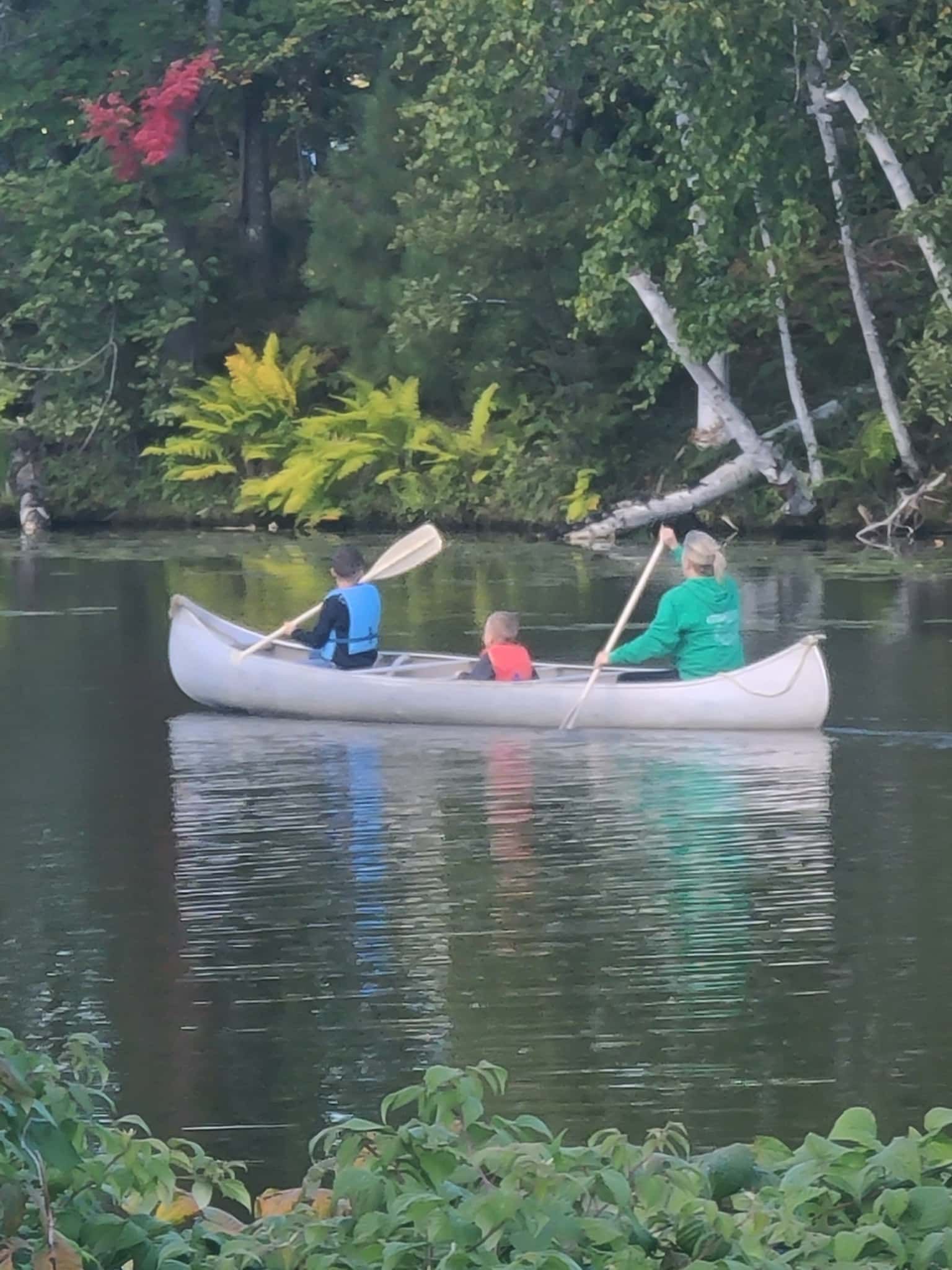 A man is paddling a kayak on a lake.
