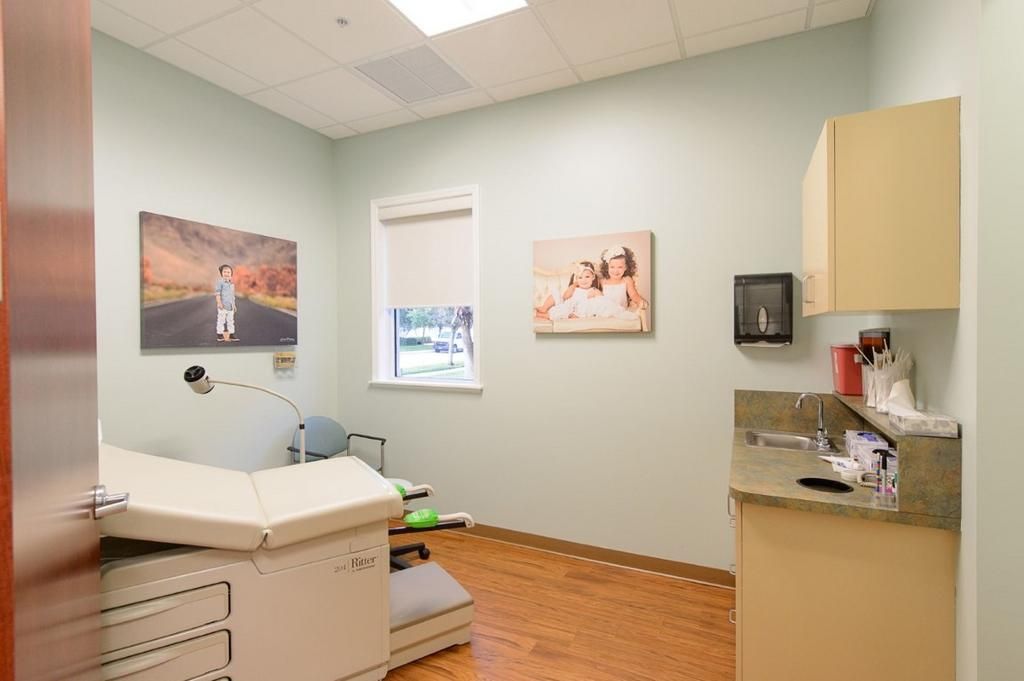 A doctor 's office with a table and a window.