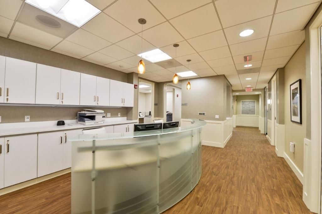 There is a long hallway with a reception desk in the middle of it.