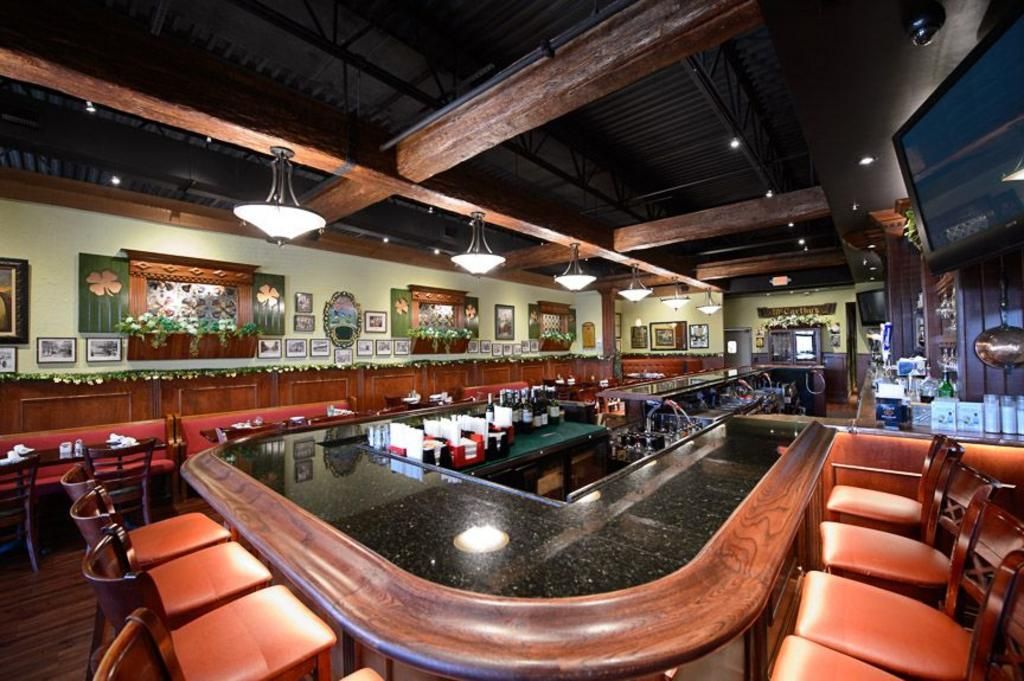 A restaurant with a long bar and stools
