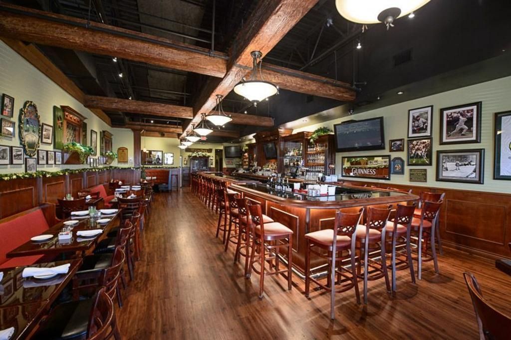 A restaurant with a long bar and tables and chairs