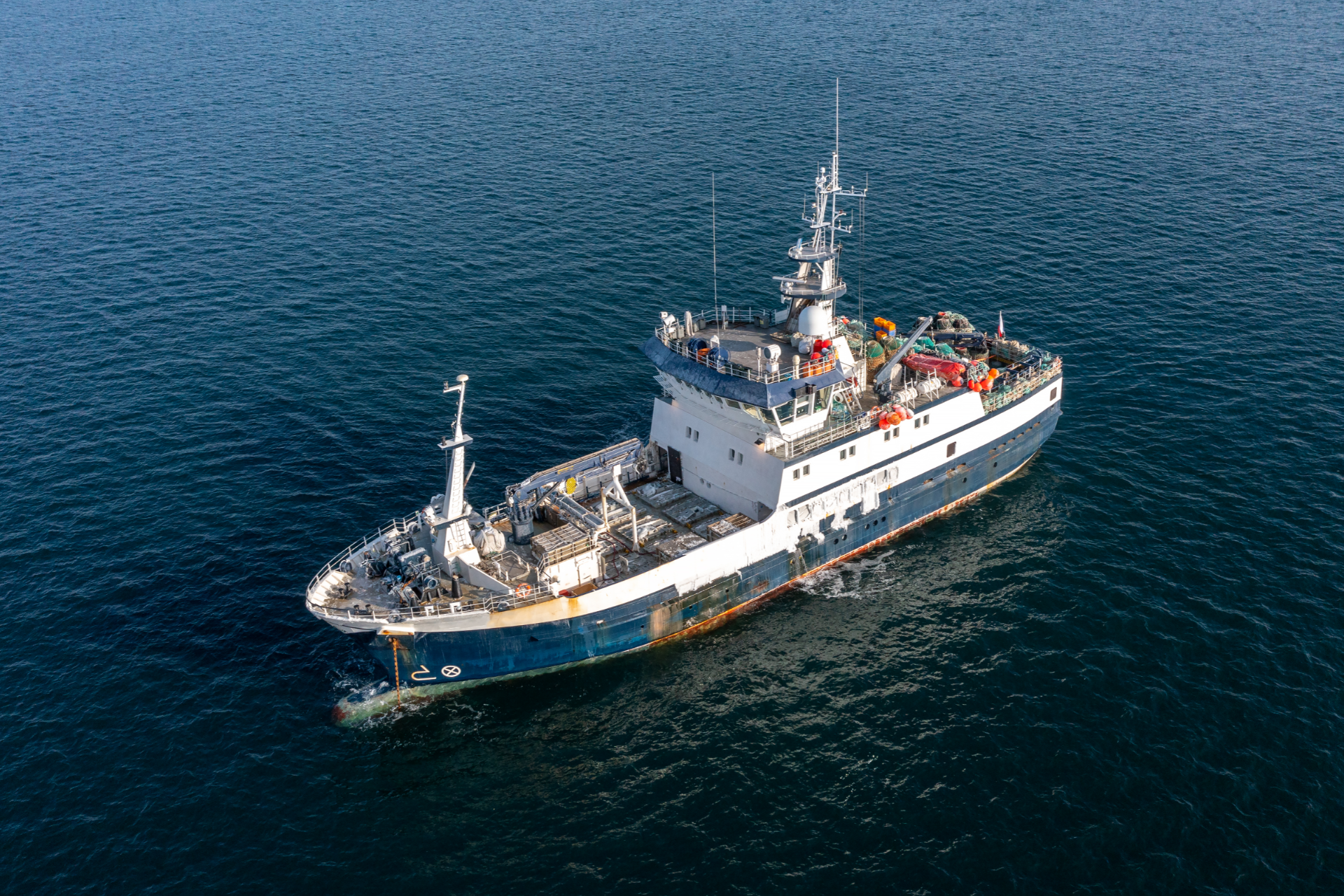 A large blue boat is floating on top of a large body of water