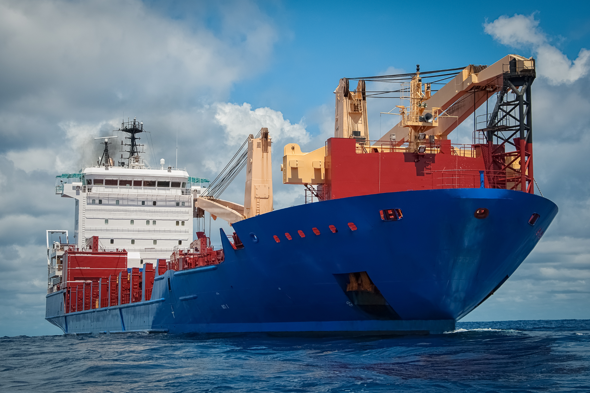 A large blue boat is floating on top of a large body of water