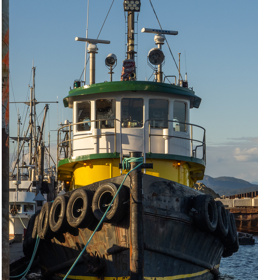 A yellow and green boat with tires on the side of it
