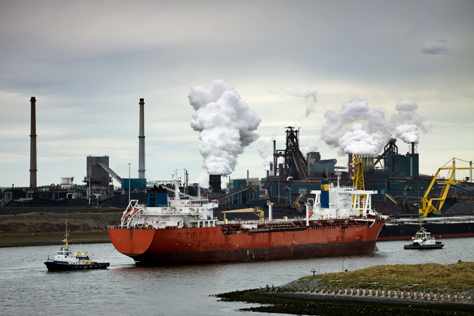 A large blue boat is floating on top of a large body of water