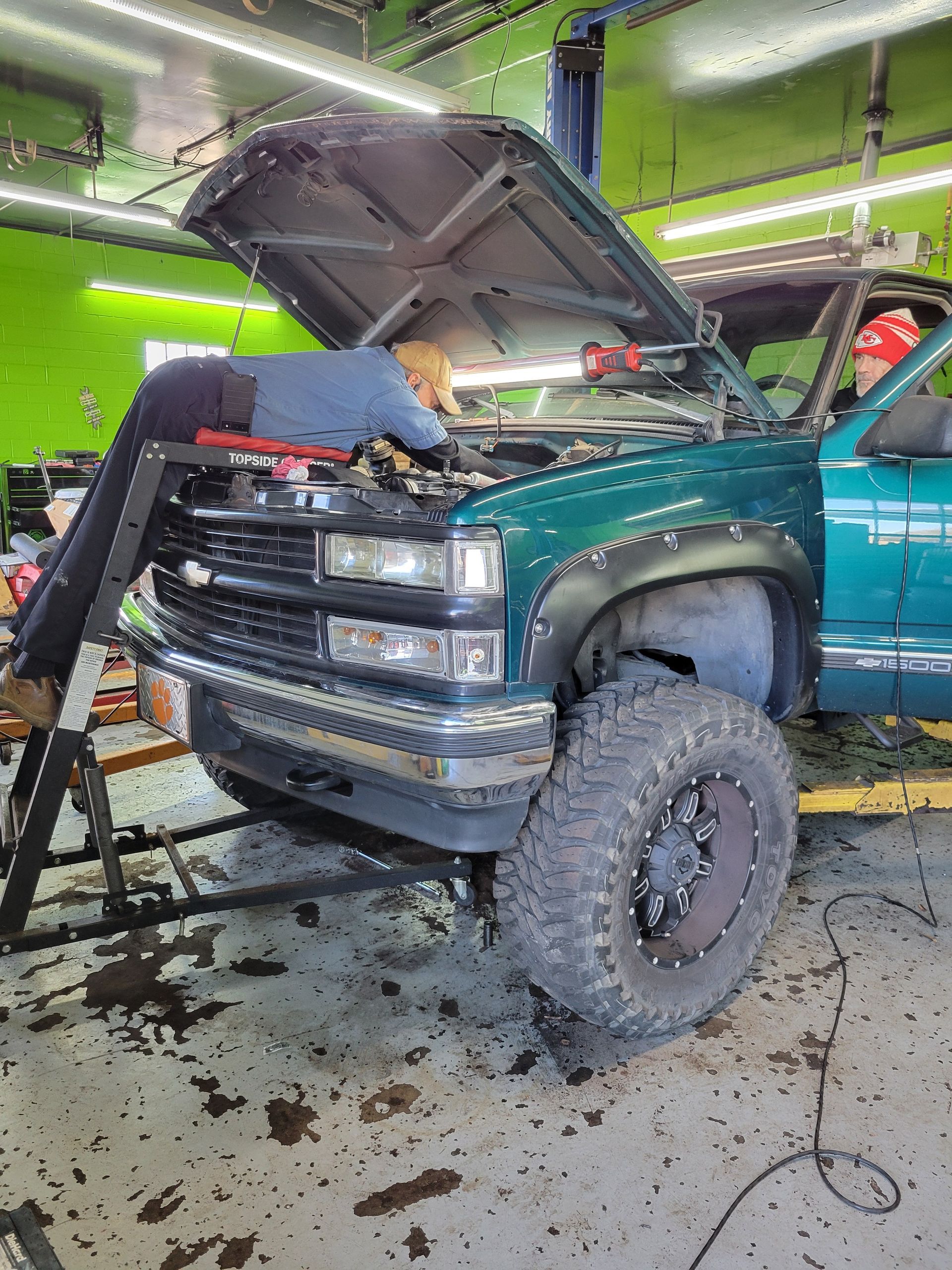 Mechanic working on green truck | Crossroads South Automotive