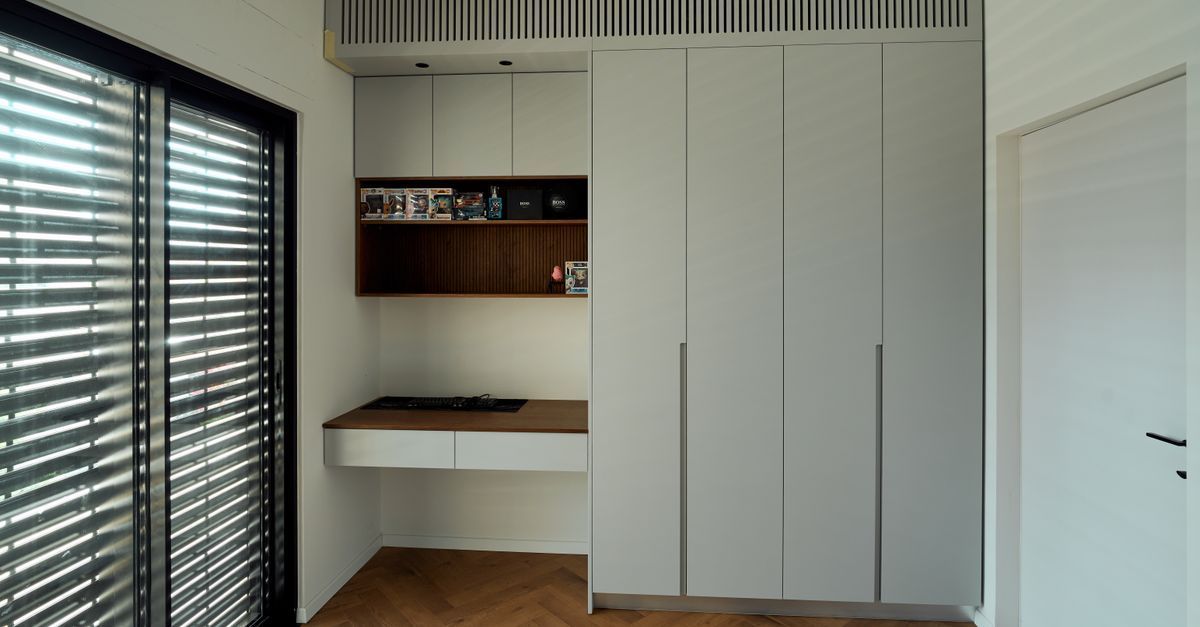 Habitación minimalista con armarios blancos empotrados