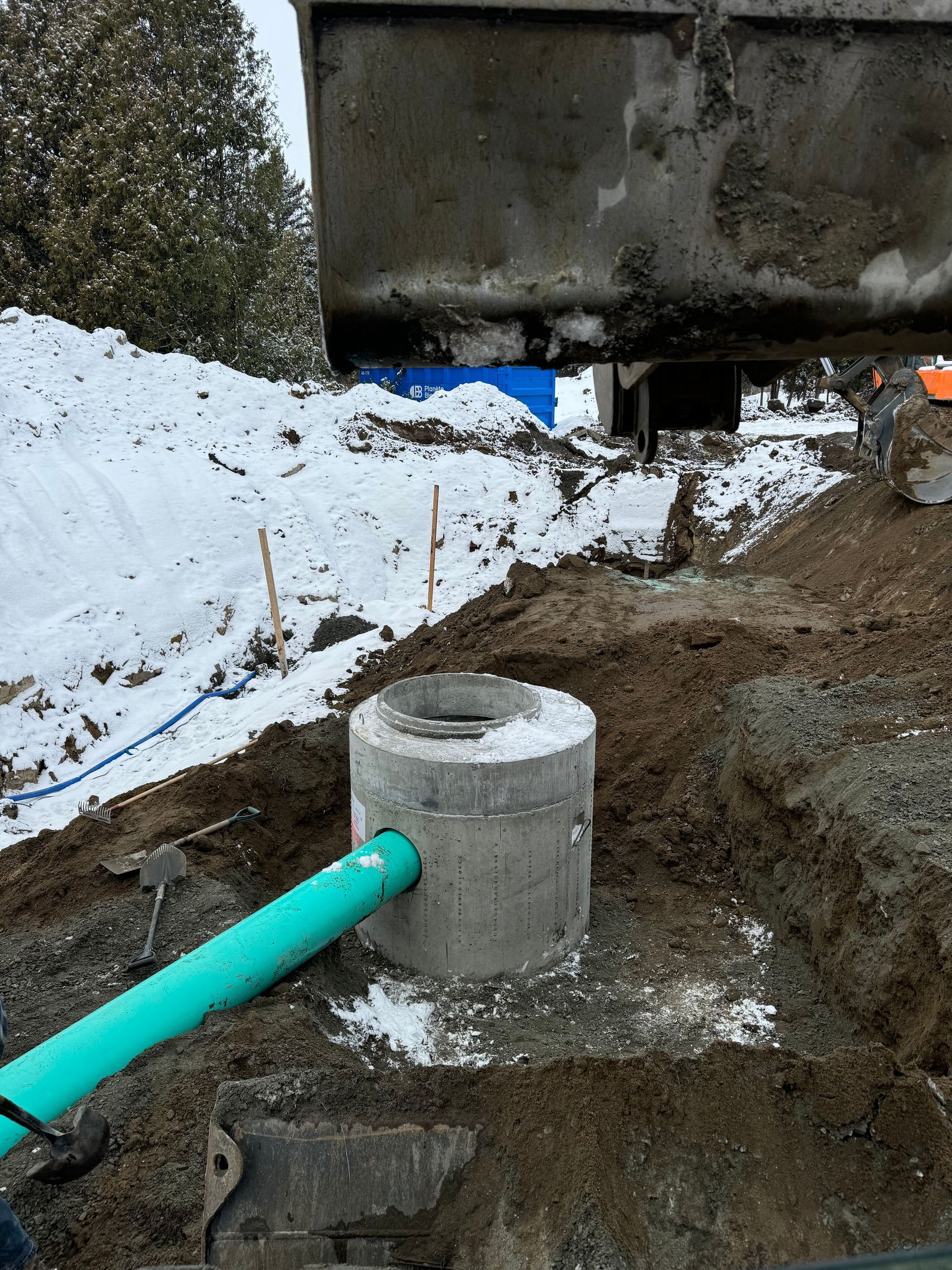 Un tuyau vert est relié à un bloc de béton dans la terre.