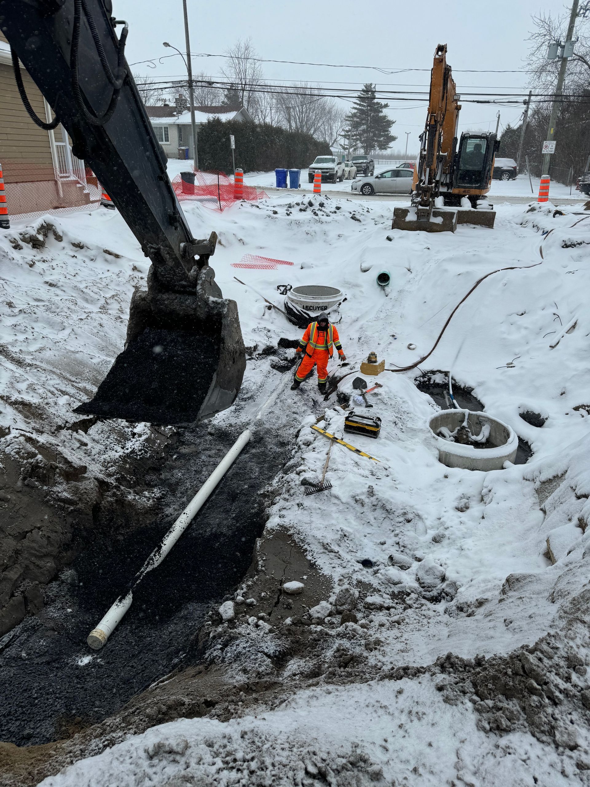 Une excavatrice creuse un trou dans la neige.