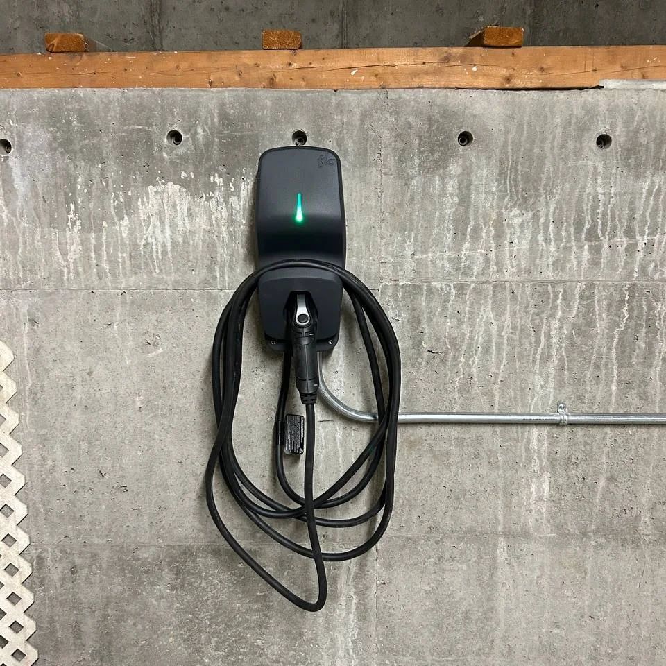 Un chargeur noir est accroché à un mur en béton.