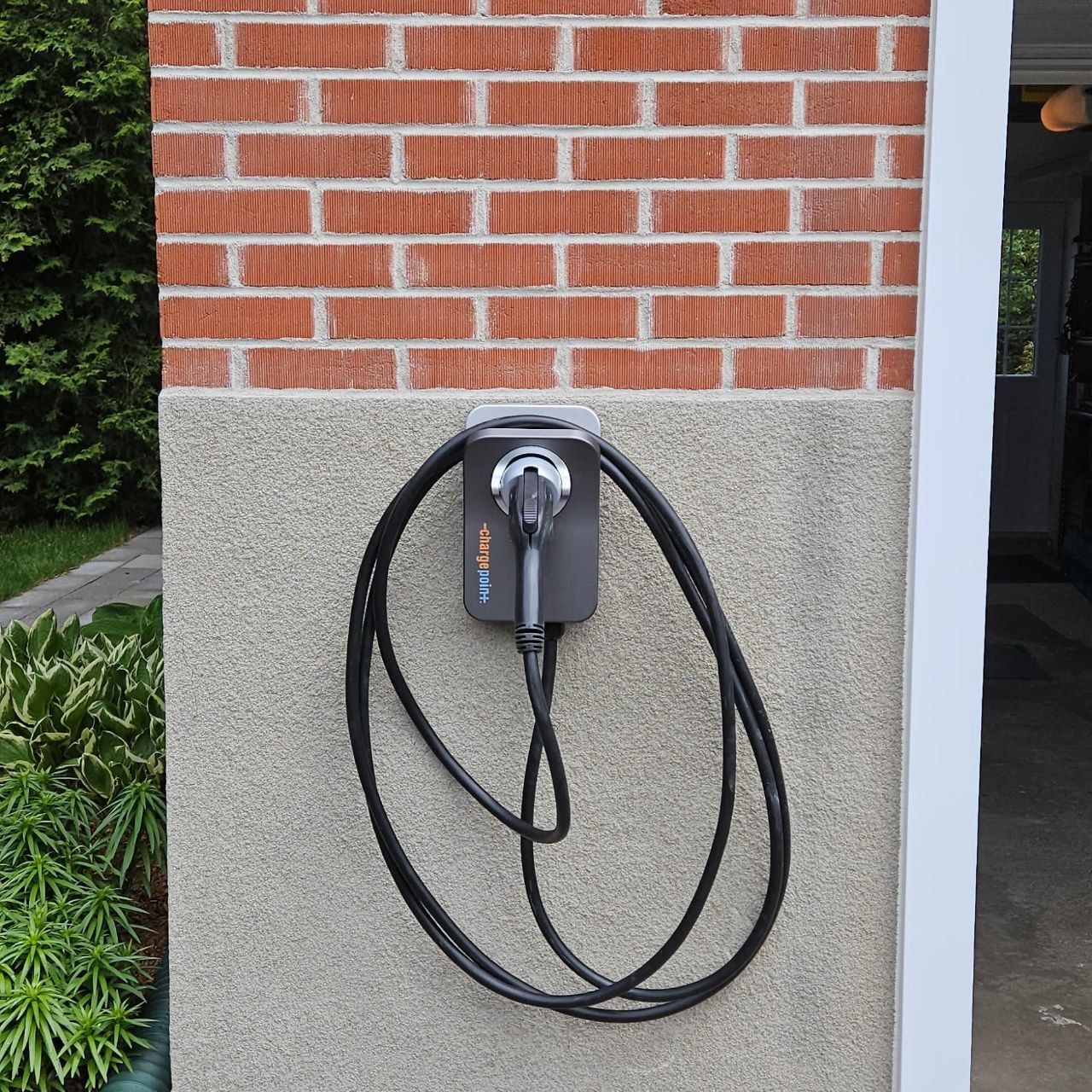 A brick wall with a black cord attached to it