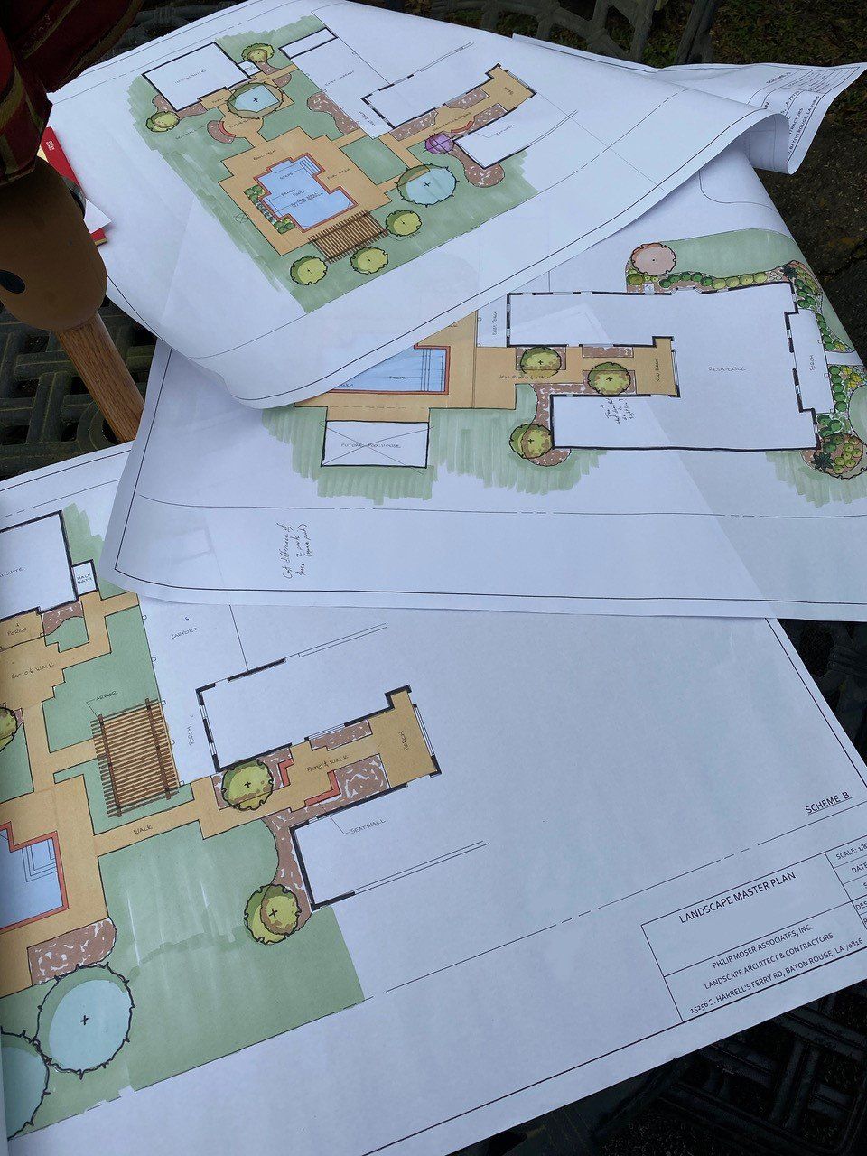 Three landscape design blueprints, with colored plans of outdoor spaces and features.
