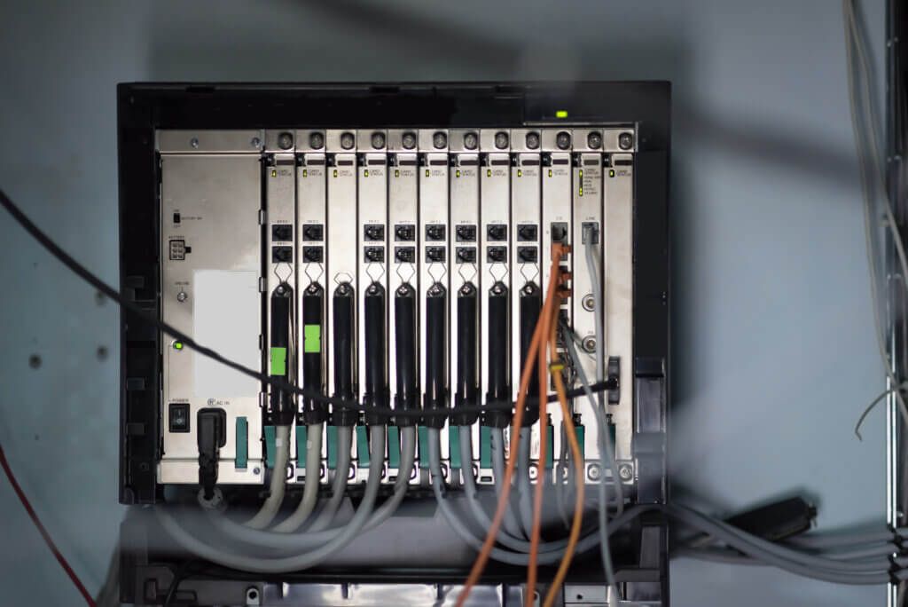 Server rack with multiple circuit boards, cables, and wires.