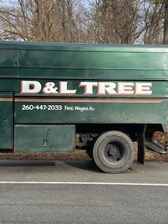 D & L Tree truck is parked on the side of the road.