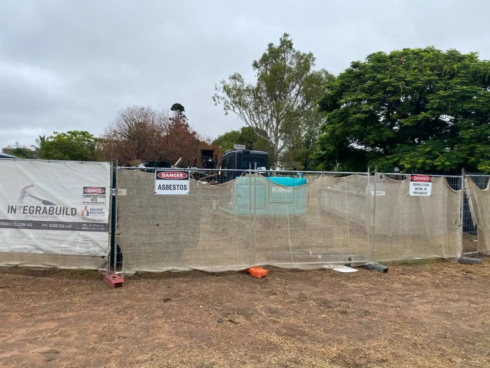 A Construction Site With A Fence And A Sign That Says ' Warning ' On It — Integrabuild in Bowen, QLD