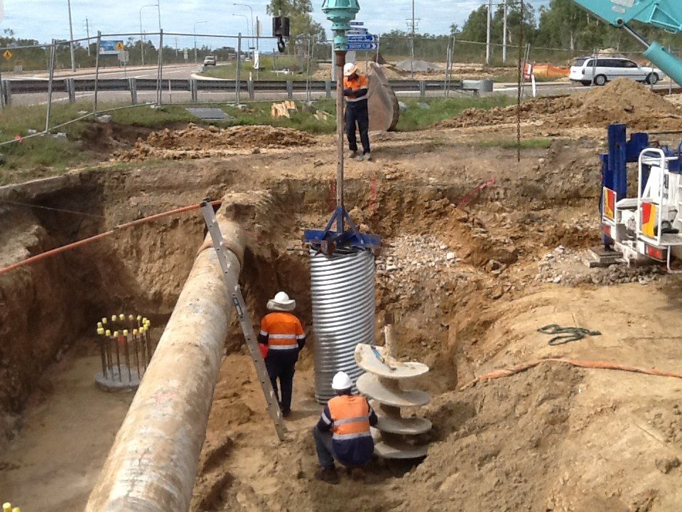 Construction Workers Are Working On A Large Pipe In The Dirt — Integrabuild in Bowen, QLD