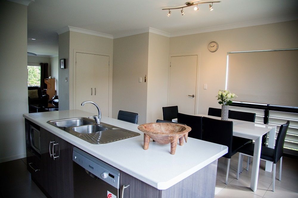 A Kitchen With A Sink And A Clock On The Wall — Integrabuild in Bowen, QLD