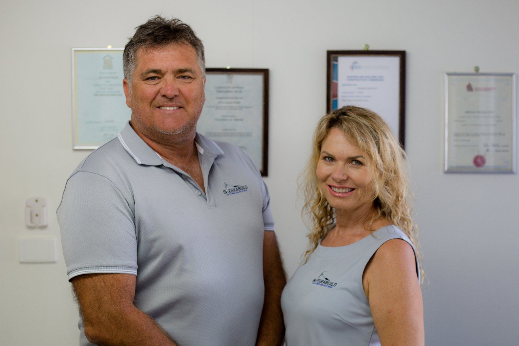 A Man And A Woman Are Standing Next To Each Other In A Room — Integrabuild in Bowen, QLD