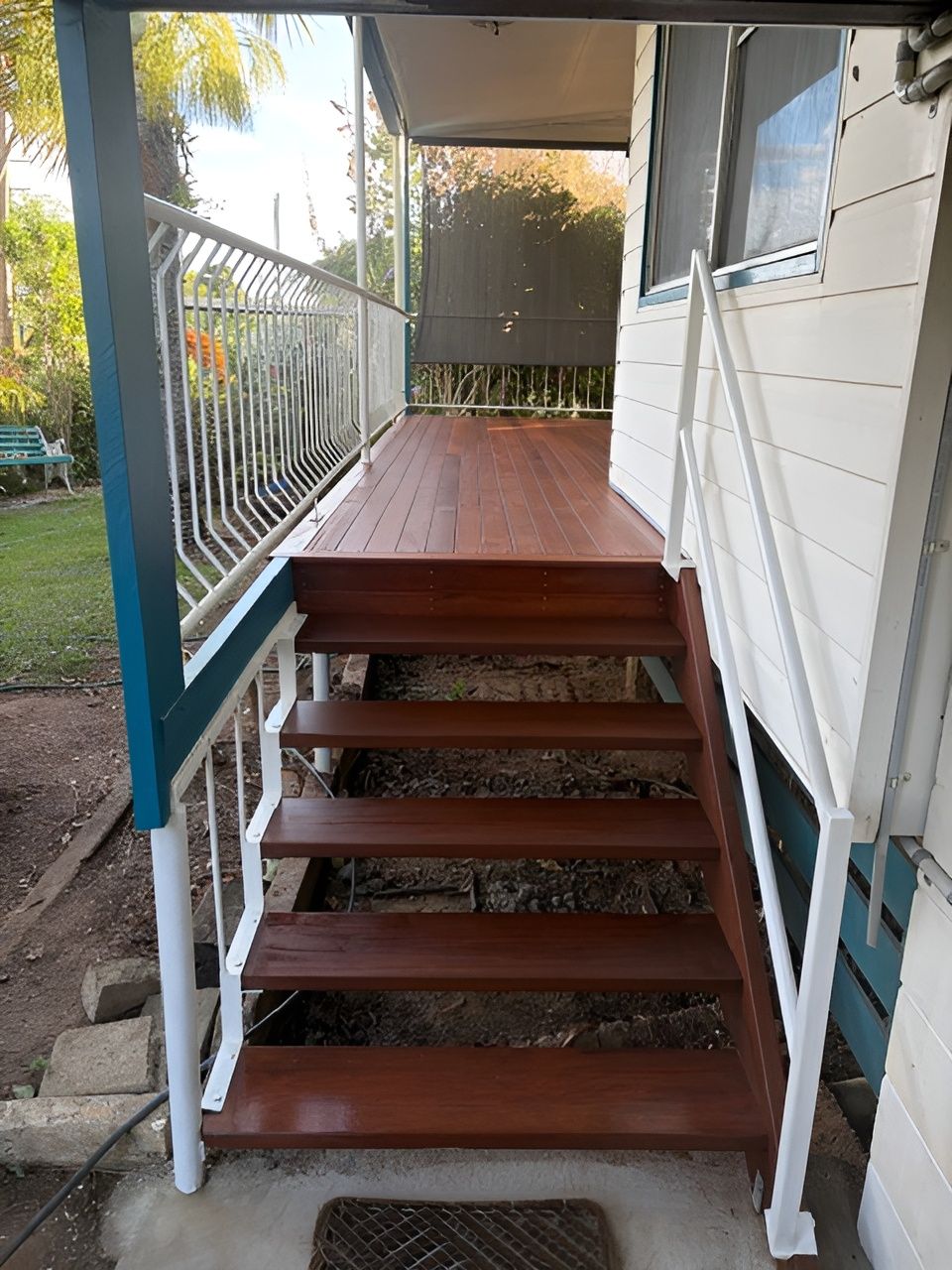 Wooden Front Porch Stairs with White Railings and A Small Deck on A House — Integrabuild in Bowen, QLD