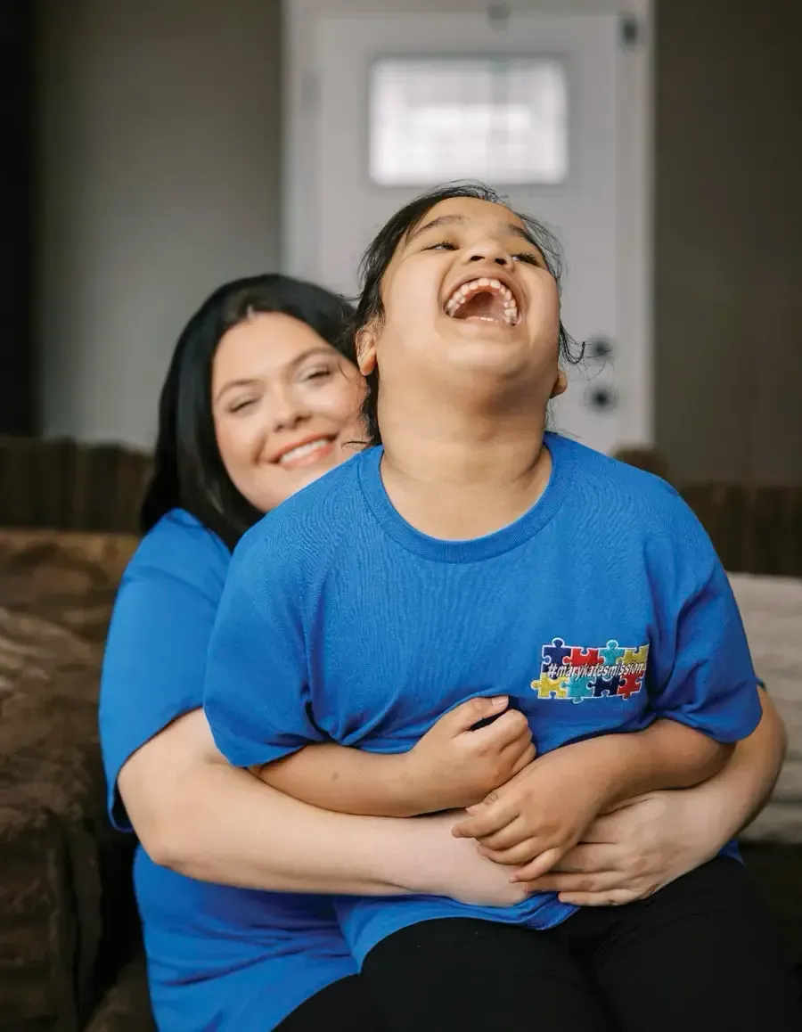 A smiling man and woman pose together in a bright, modern living space.