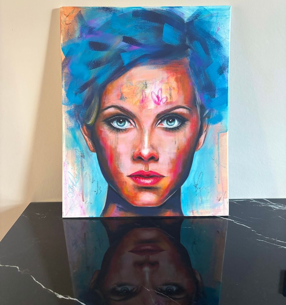 Kleurrijk portret van een vrouw met blauw haar en intense ogen op een reflecterende zwarte achtergrond.