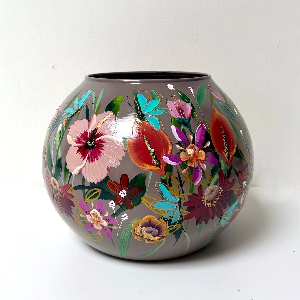 Keramische vaas met bloemenmotief, met roze, paarse en turquoise bloemen op een lichte achtergrond.