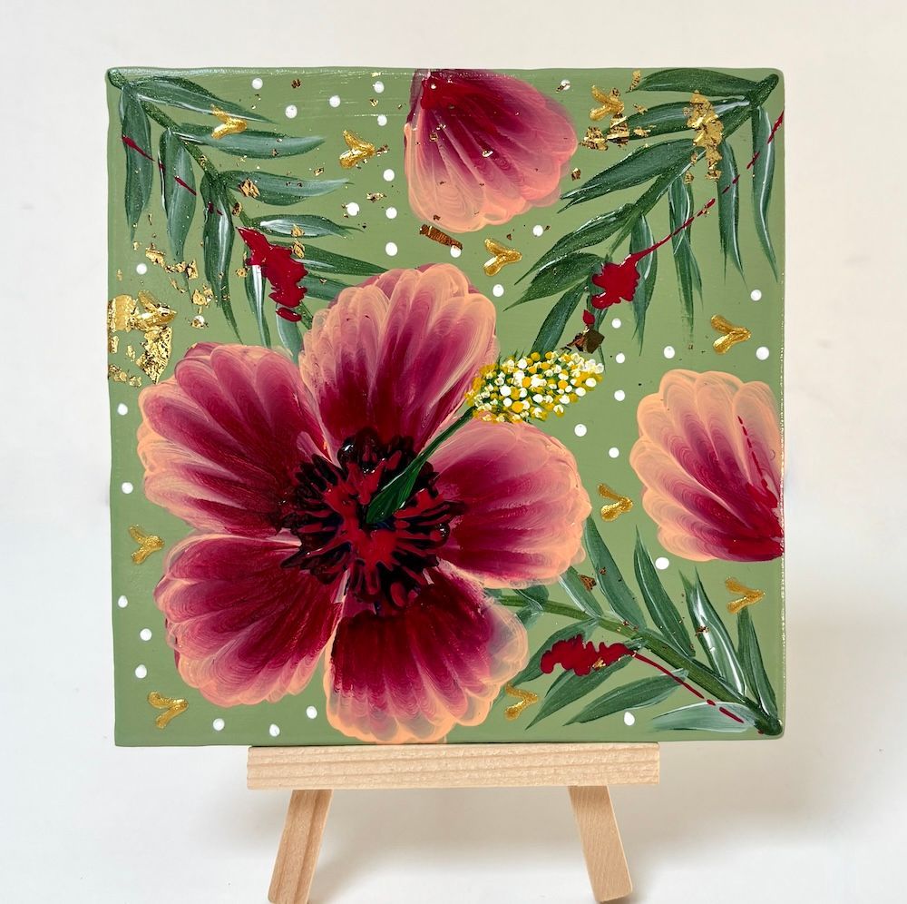 Bloemschilderij op een klein schildersezel, met roze bloesems op een groene achtergrond en gouden accenten.