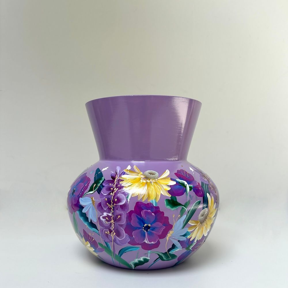 Paarse, met bloemen beschilderde keramische vaas met een uitlopende bovenkant op een lichte achtergrond.