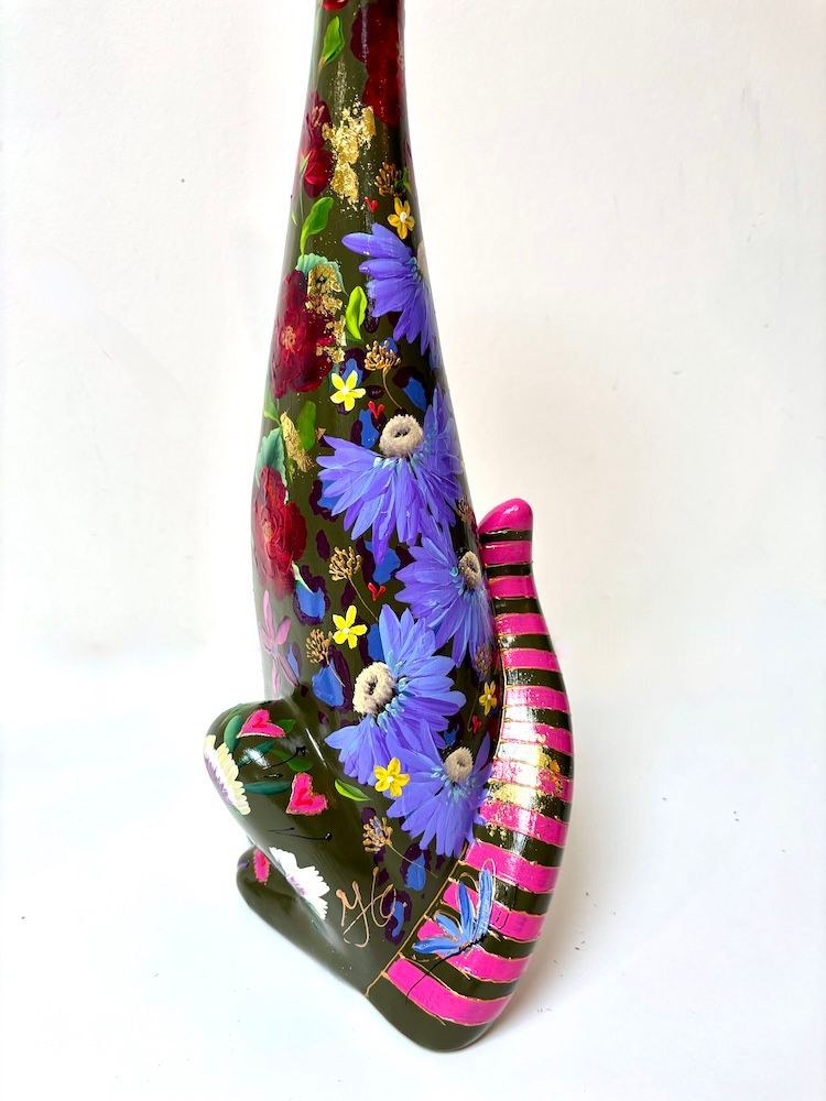 Hoge zwarte kattensculptuur met kleurrijke bloemenpatronen op een witte achtergrond