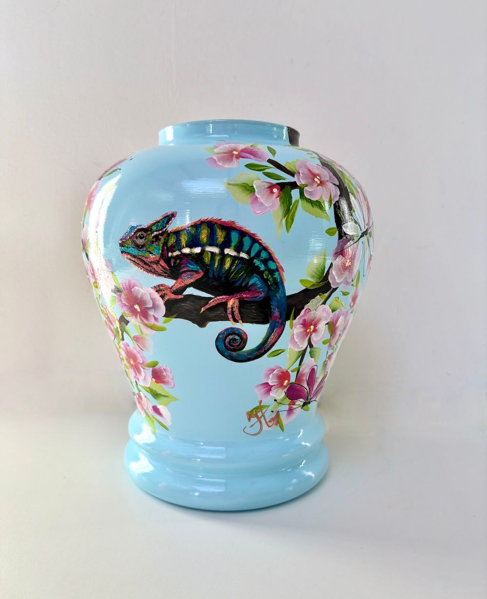 Blauwe keramische vaas met een kleurrijk ontwerp van kameleons en roze kersenbloesems.