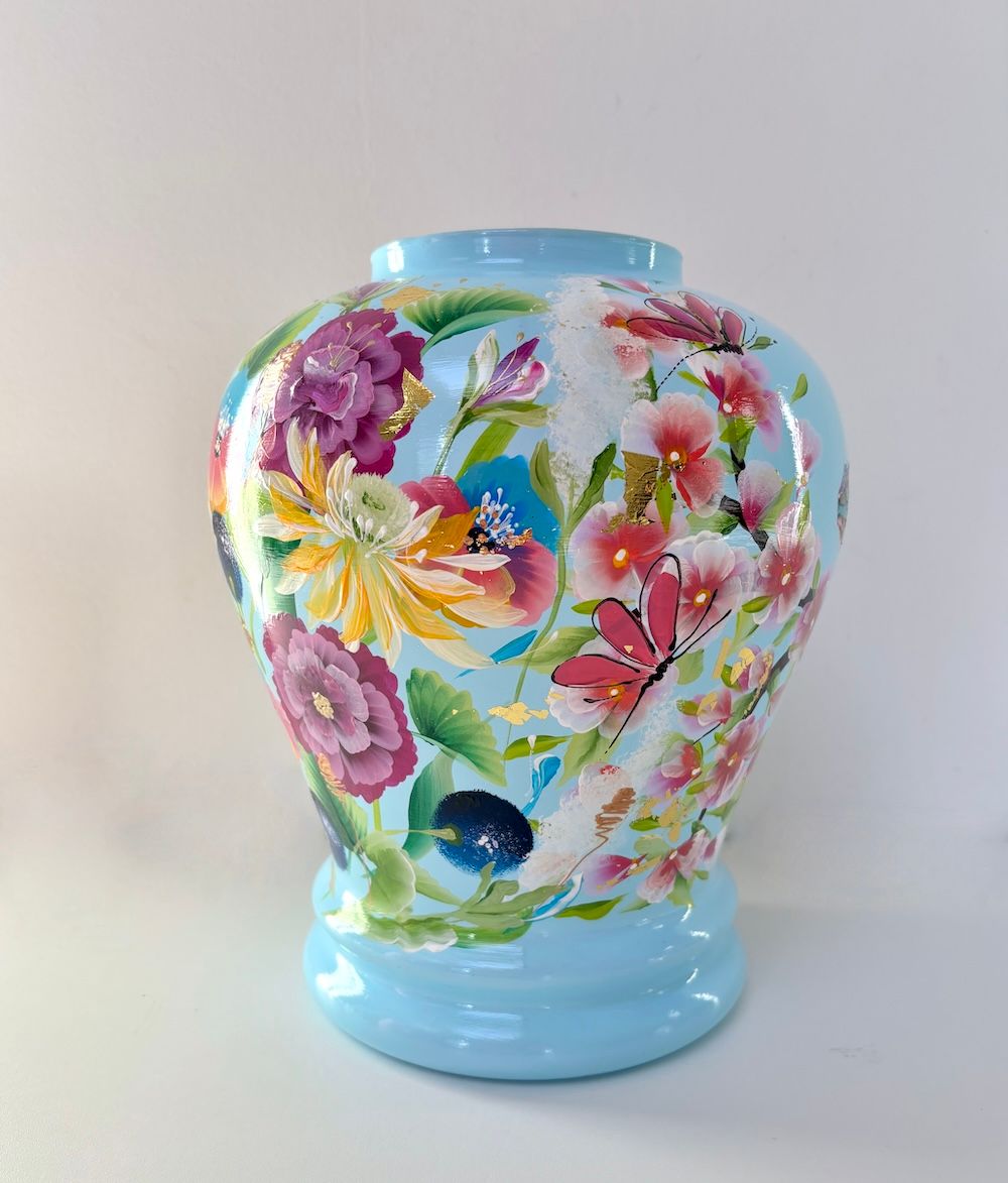 Blauwe keramische vaas met een kleurrijk ontwerp van kameleons en roze kersenbloesems.