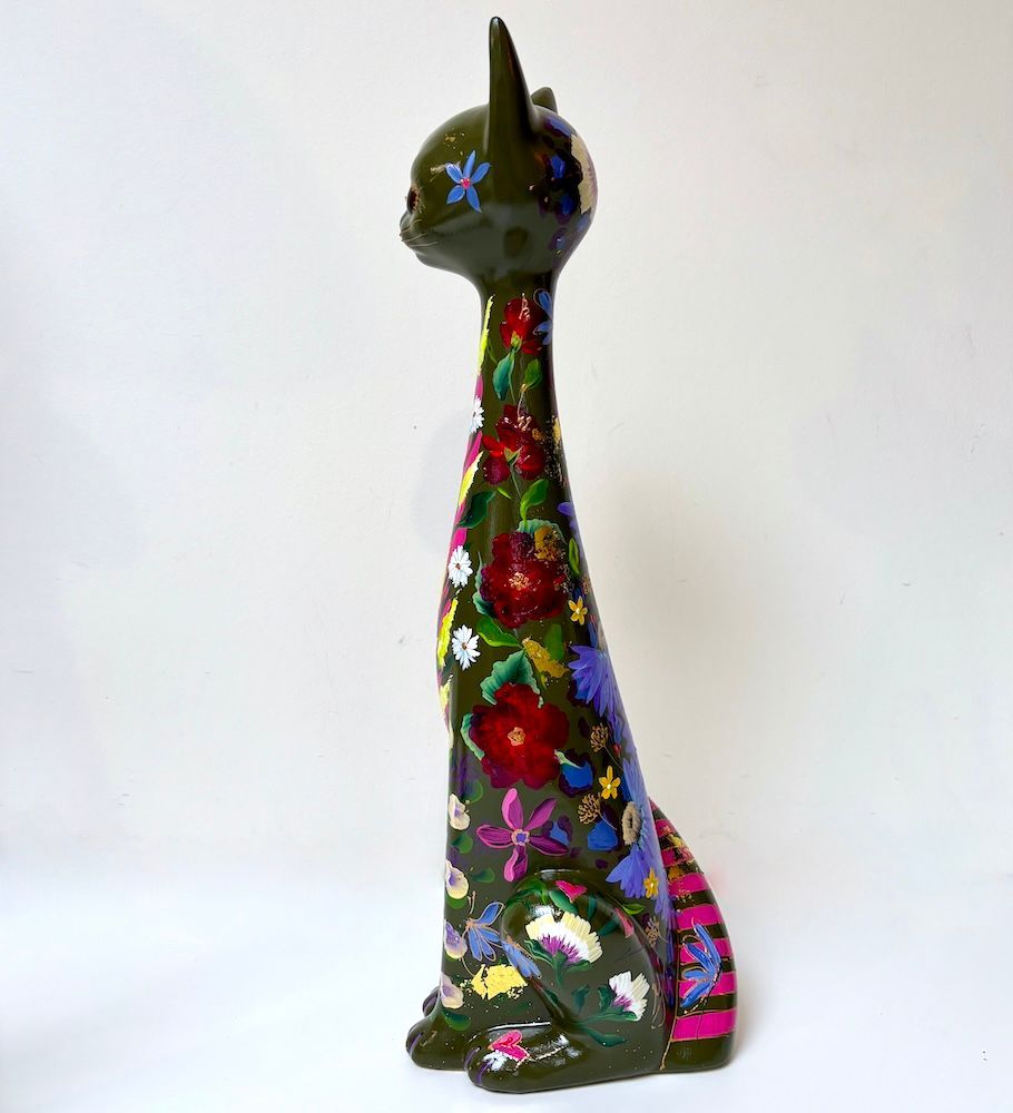 Hoge zwarte kattensculptuur met kleurrijke bloemenpatronen op een witte achtergrond