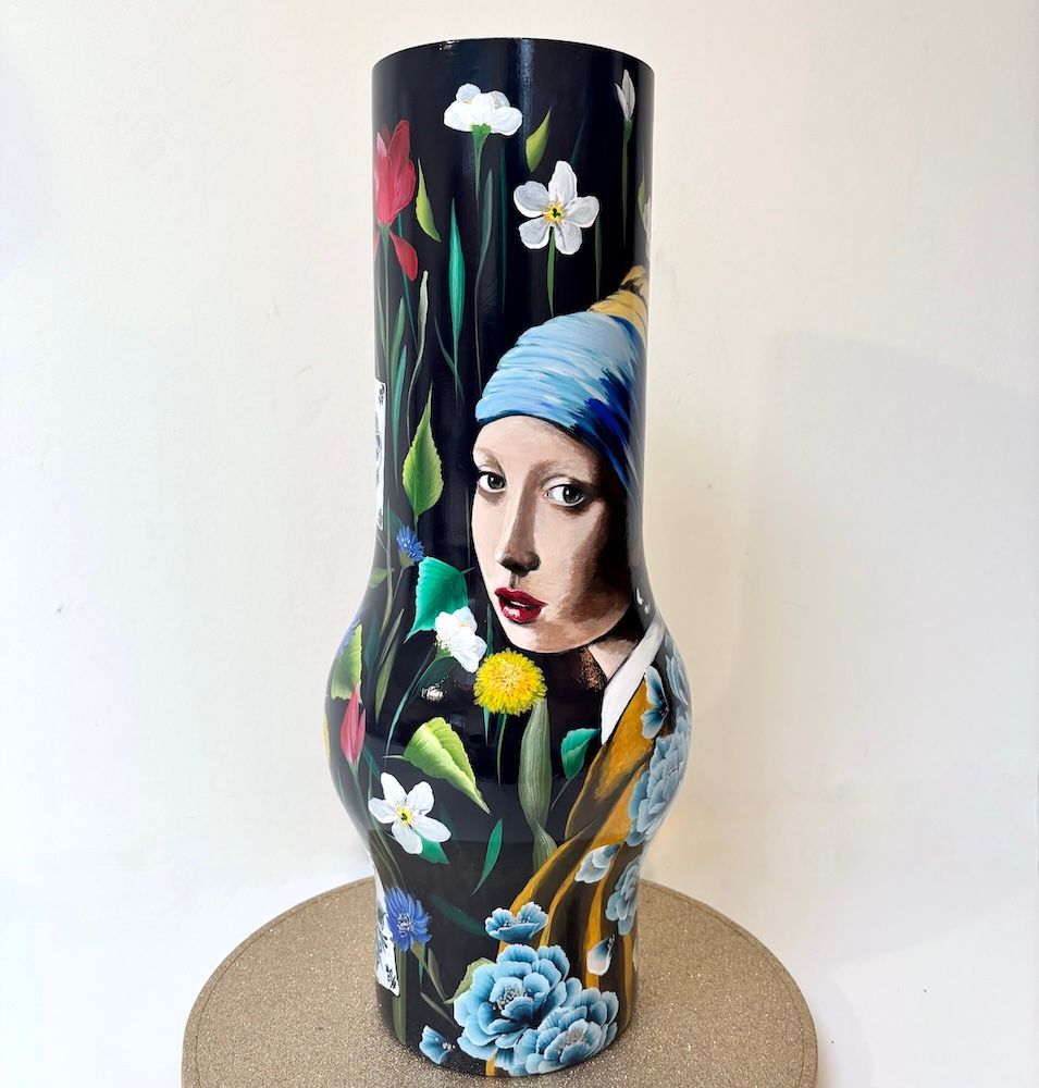 Decoratieve vaas met bloemenmotief en een portret van een vrouw met een blauwe hoofddoek.