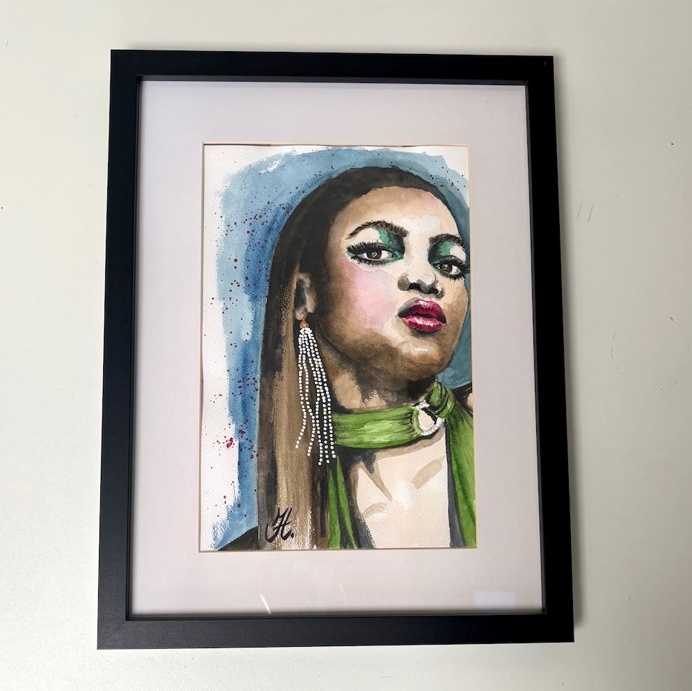Ingelijst aquarelportret van een persoon met een blauwe achtergrond, een groene choker en rode lippenstift.